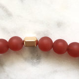 Men's red carnelian beaded energy fertility bracelet close up on gold hexagon bead